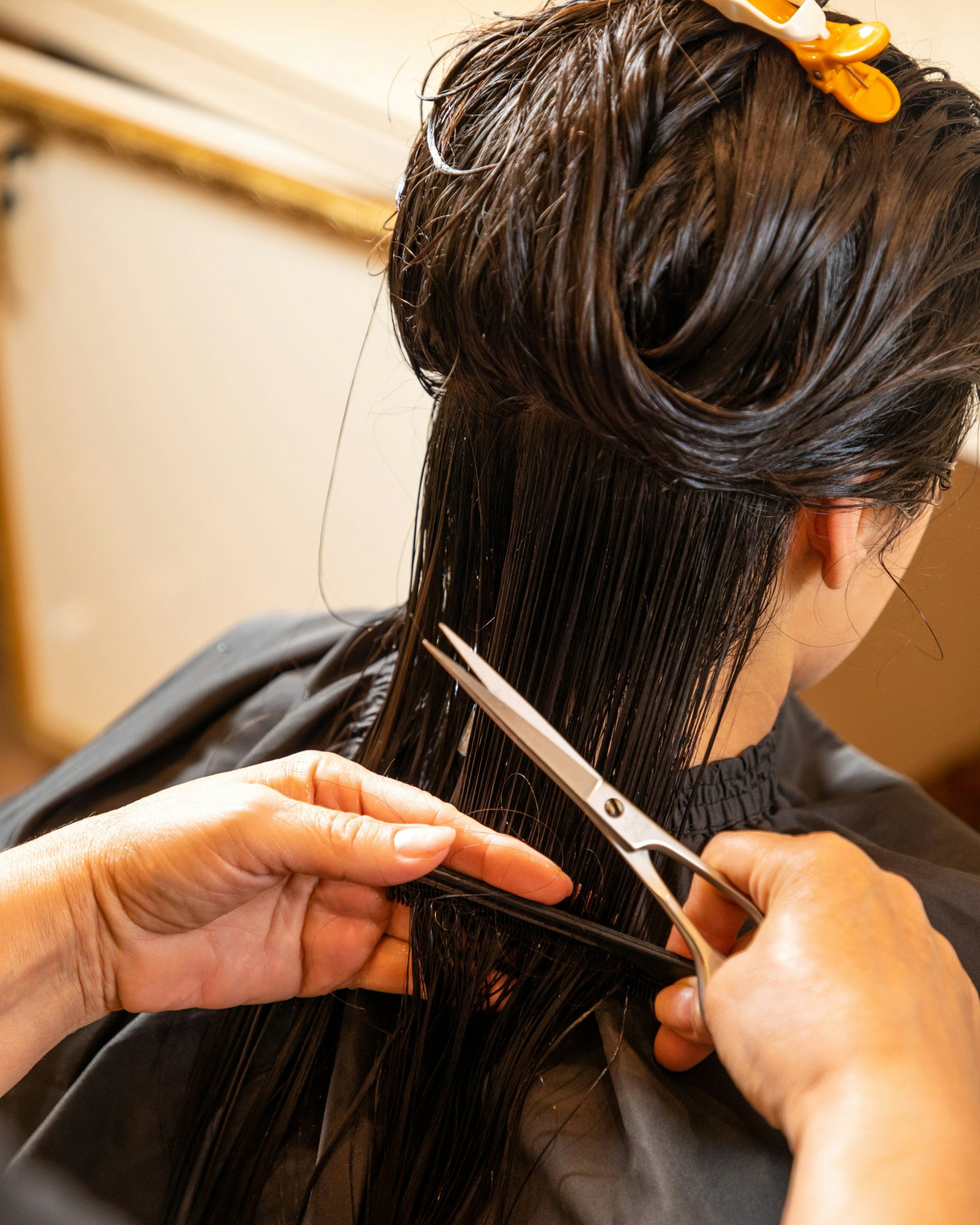 Eine Frau schneidet einer anderen Frau mit einer Schere die Haare